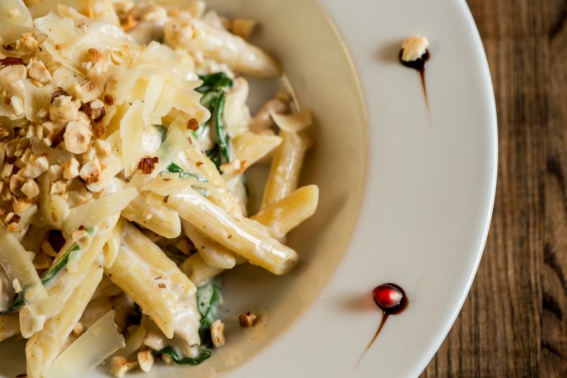 Penne with chicken, spinach, and hazelnut in parmesan sauce