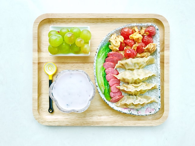 Colorful toddler snacks on a wooden plate