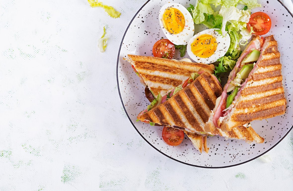 turkey sandwich with tomatoes, lettuce, and avocado