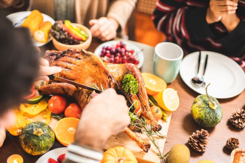 A roast turkey being sliced on a dinner table