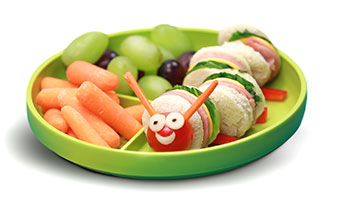 baby carrots, grapes, and ham sandwich presented as a caterpillar on a plate