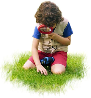 child looking into a magnifying glass with binoculars hanging on his neck