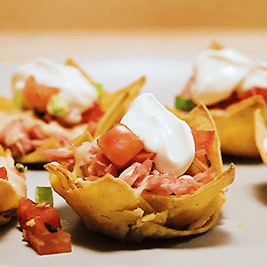 nacho cups with meats, tomato, and cheese